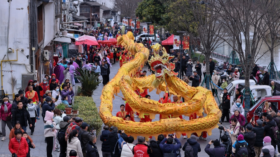 昨天，三林老街锣鼓喧天，百米巨龙翻腾游走，市民在观看舞龙表演。记者 赖鑫琳 摄.jpg